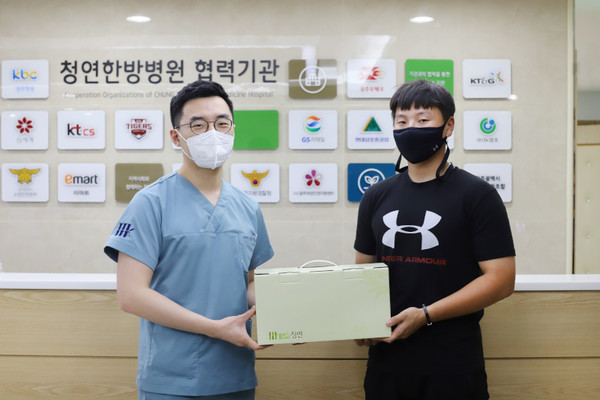 청연한방병원 김지용 원장(왼쪽)이 최성민 선수에게 한약을 제공하고 있다. 청연한방병원 제공