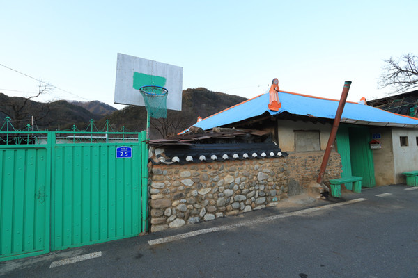 “우리 막내아들이 애기들 놀라고 맨들았지.” 골목쪽 담벼락에 농구대가 있다.