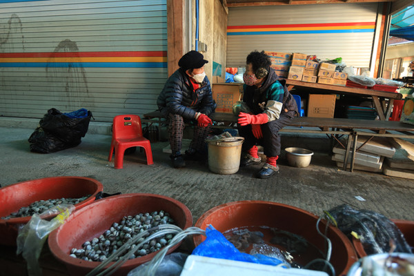 곁을 지켜주고 맞들어주는 이의 온기로 겨울 장터를 건너간다. 어물전의 돌산댁과 용동댁.