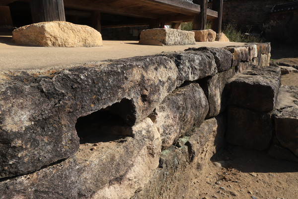 돌을 쌓아 올린 기단부에 네모진 구멍 하나를 비워 놓았을 뿐인 굴뚝. 이진래 고택.