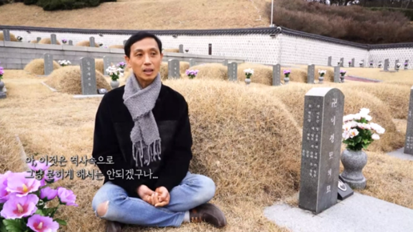 국립5.18묘지에 안장된 형 이정모 씨 묘지 앞에 앉은 이해모씨. 최성욱 감독 제작 텀블벅 펀딩용 영상 중에서
