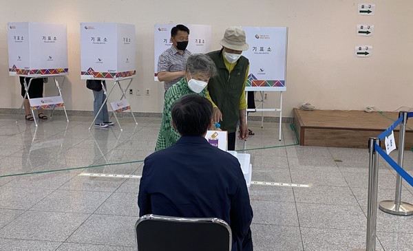 제8회 전국동시지방선거 사전투표 첫날인 27일 광주 북구 전남대학교 컨벤션홀에 마련된 사전투표소에서 투표를 마친 어르신 부부가 투표용지를 투표함에 넣고 있다.