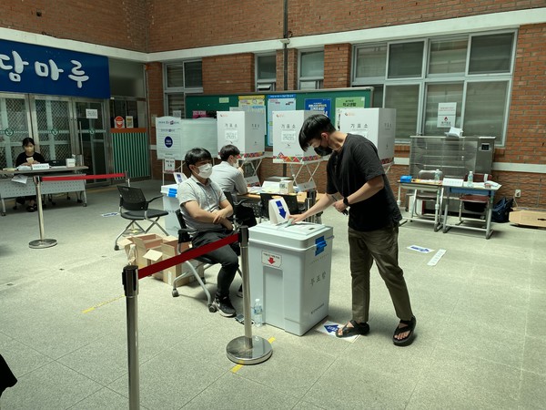 6·1전국동시지방선거 본투표날 광주시 서구 전남고등학교에 마련된 투표소에서 투표를 마친 유권자가 투표용지를 투표함에 넣고 있다.