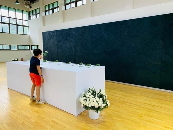 5·18 사적지인 광주 동구 상무관에 전시된 예술작품 '검은 비' 앞에서 한 학생이 추모하고 있는 모습.