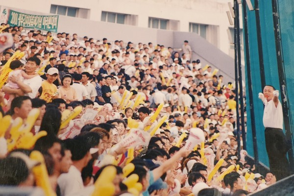 무등야구장 외야 난간에 올라 응원을 유도하는 김창규 해태 타이거즈 응원단장. 김창규 씨 제공.
