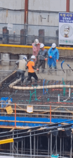 비가 내린 지난 17일 오전 9시경 화정동 인근 신축 아파트 건설 현장에서 콘크리트 타설 작업을 하고 있는 작업자들. 제보자 제공.