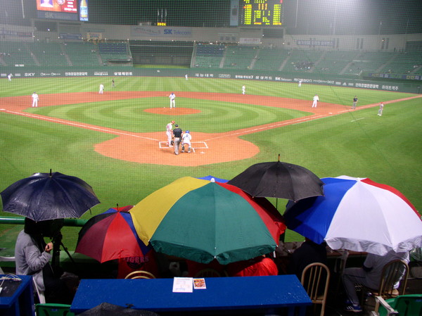 2004년 기사 작성 당시 옛 무등경기장 모습. 비가 내리는 가운데 진행된 경기를 관람하는 관객들이 우산을 쓰고 있다. 광주드림 자료사진.