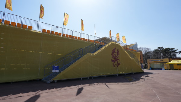 육상트랙 위에 설치된 응원석. 가림막 사이로 철골구조물들이 비쳐보인다.