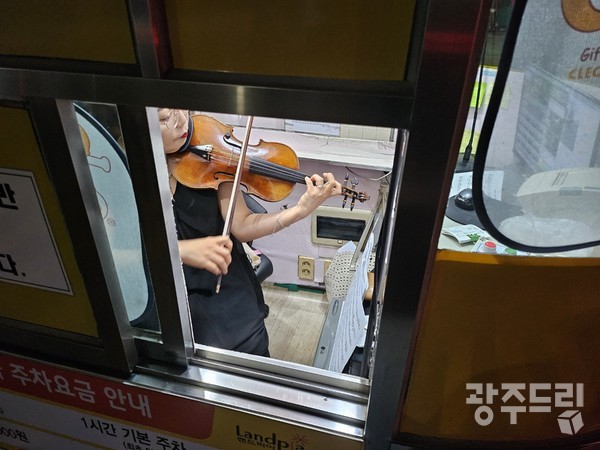 1평 남짓한 주차부스 안에 보면대와 악보를 놓고 연주하고 있는 박나원(54) 씨.