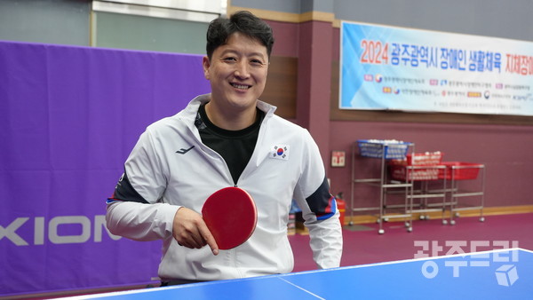 2024 파리 패럴림픽 탁구 동메달리스트 김정길 선수가 서구 장애인실업팀 탁구대에서 포즈를 취하고 있다.
