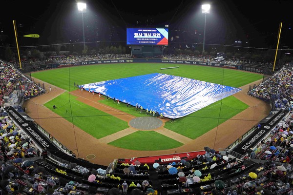 21일 기아챔피언스 필드에서 진행된 2024 KBO 한국시리즈 1차전. 우천으로 인해 개막 행사가 지연되고 방수포를 까는 모습이다. 기아타이거즈 제공