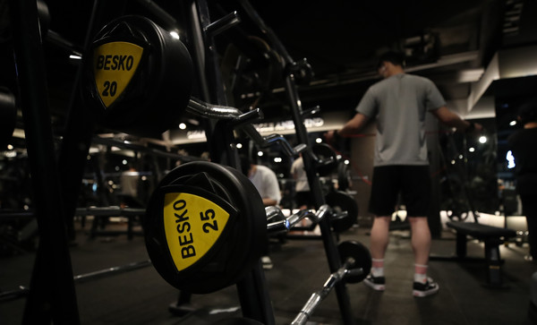 헬스장을 찾은 고객이 덤벨 운동을 하고 있다. 사진은 기사내용과 관계 없음. 뉴스1.