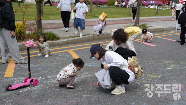 게임존에서 분필로 그림을 그리고 있는 가족들. 
