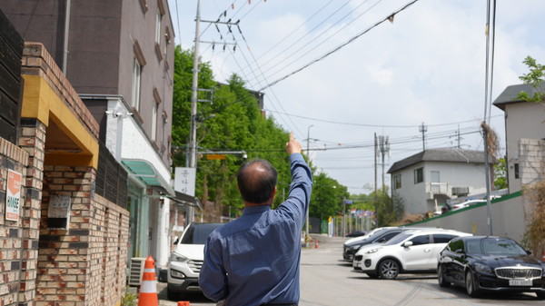 운암3동 재건축단지 방향 임시 전력 공급되는 고압선 가리키는 제보자.