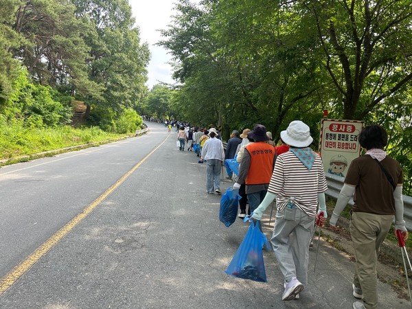 순례길을 걸으며 환경 미화 활동을 병행하는 참가자들