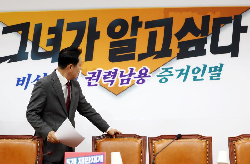 장동혁 국민의힘 대표가 3일 오전 서울 여의도 국회에서 열린 최고위원회의에 참석하며 배경에 적힌 문구를 살펴보고 있다. 뉴시스