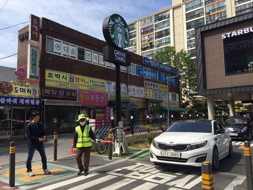 ?스타벅스에서 보행자 통행 안전 시니어 서비스맨으로 일하고 있는 어르신. 서구 제공